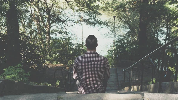 Young man sits, thinks,lonely man sits on the step,close-up.Sad guy, desperate man