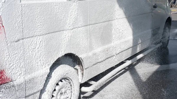 Car at a car wash,wash the car with soapy foam,close-up.Wash the dirt off the truck.