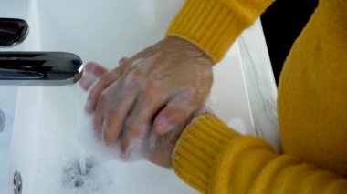 Ellerini musluğun altında sabunla yıka. Suyla yakından çek.