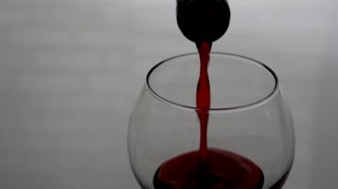 Şarap bardağına şarap dök, kırmızı şarap bardakta beyaz tuğladan bir arka planda