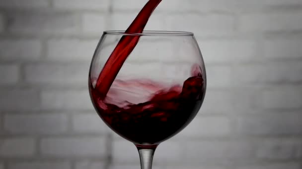 白レンガの壁の背景にガラスにワインを注ぐ ワインのクローズアップ — ストック動画