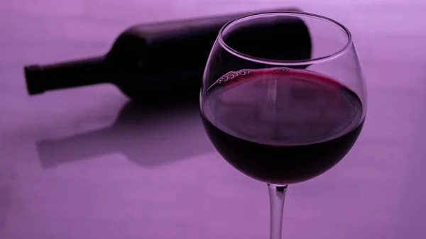 Szklanka Czerwonego Wina Butelką Różowym Tle — Zdjęcie stockowe
