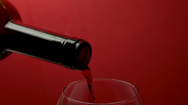 在红色底色的酒杯中倒入红酒 — 图库视频影像