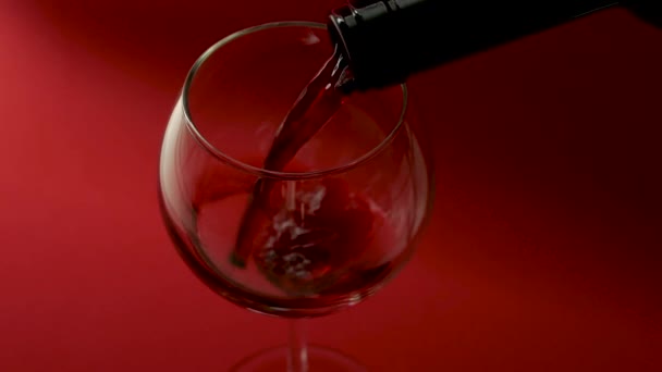 Tuangkan Anggur Merah Dari Botol Gelas Dengan Latar Belakang Merah — Stok Video