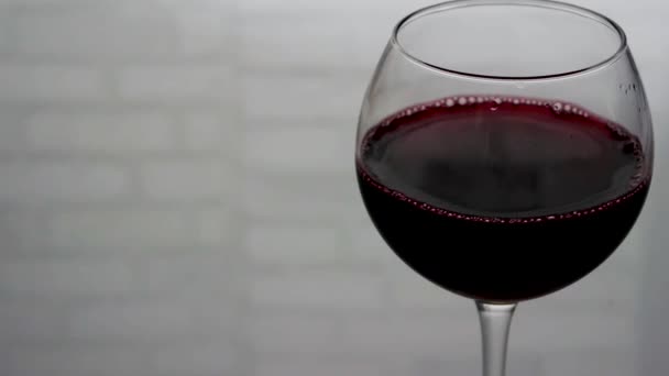 Rode Wijn Een Wijnglas Een Witte Bakstenen Achtergrond Close Van — Stockvideo