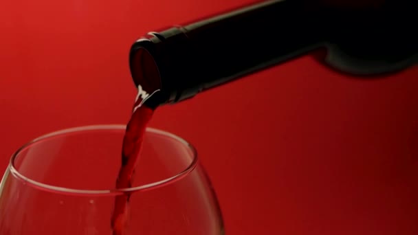 Verser Vin Rouge Une Bouteille Dans Verre Sur Fond Rouge — Video