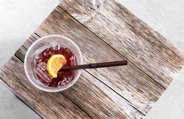 Fresh ice cold drink in top view on old wooden table.