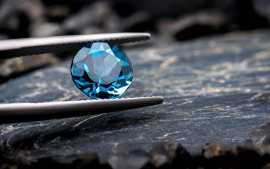 Mavi topaz gemstone takı fotoğraf siyah taş ve karanlık aydınlatma.