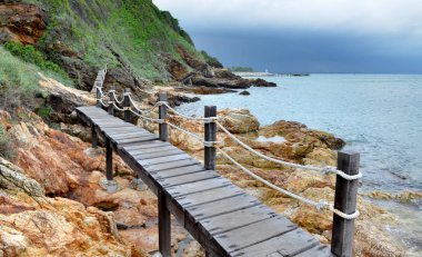 Dağ tarafı ve deniz fotoğraf açık bulut aydınlatma ile ahşap köprü