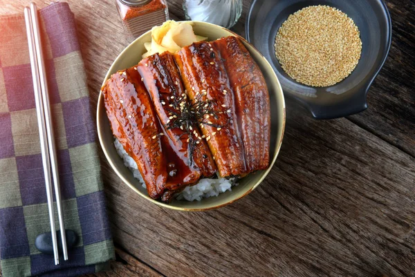 日本烤鳗鱼与甜酱在米杯或 Unagi Kabayaki 在日本菜单名称照片与室内照明 — 图库照片