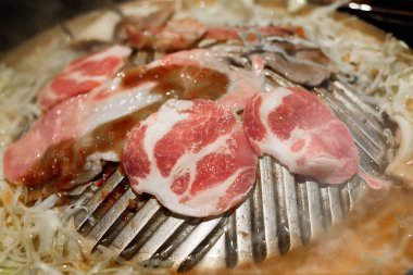 Dilim ızgara domuz Barbekü demir tava ile sebze ve çorba su kapalı düşük aydınlatma ile.