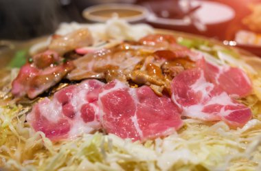 Dilim ızgara domuz Barbekü demir tava ile sebze ve çorba su kapalı düşük aydınlatma ile.