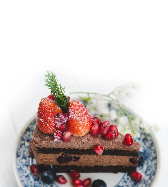 Chocolate cake topping with strawberry and berry fruits.