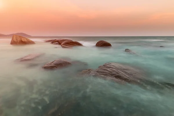 La roca y el mar en el color de la puesta del sol . —  Fotos de Stock
