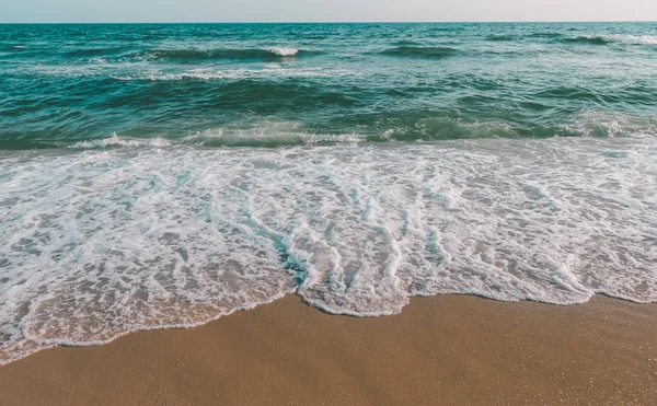 Морская волна и коричневый песчаный пляж в сером тоне . — стоковое фото