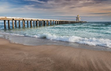Denize plajda çimento yürüyüş köprüsü.