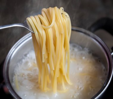 Kaynar su tenceresinde sarı erişte veya spagetti pişirme.