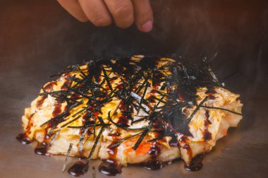 Japon pizzası okonomiyaki ocakta Teppanyaki usulü yemek yapıyor..