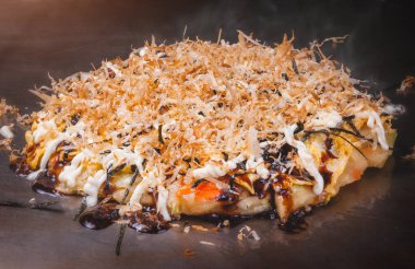 Japon pizzası okonomiyaki ocakta Teppanyaki usulü yemek yapıyor..