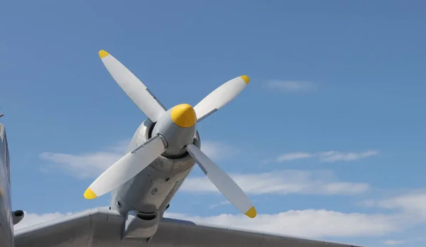 The propeller engine of the aircraft on the wing, against the blue sky.