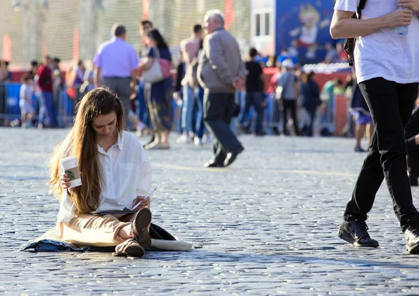 2018.07.08, Moscow, Rusya Federasyonu. Kızıl Meydan üzerinde oturan ve kitap okuma genç bir kız. Rusya'nın insanlar.