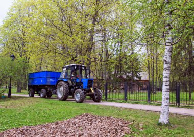 2018.05.04, Moscow, Rusya Federasyonu. Arka plan ağaç bahar Park üzerinde mavi bir traktör. Cityscape Moskova.