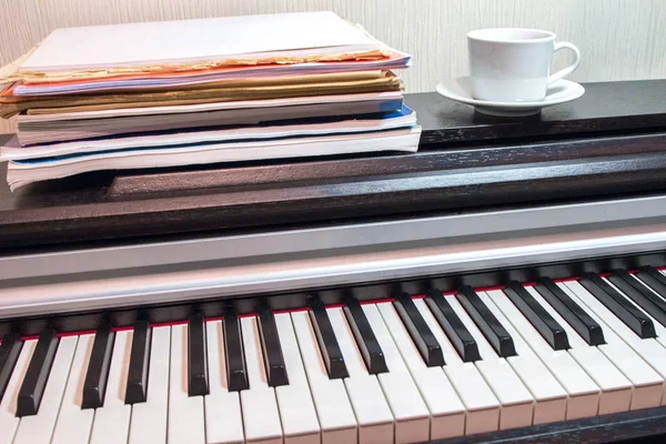 Una Pila Partituras Platillo Blanco Una Taza Piano Abierto Músculo — Foto de Stock