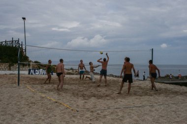 09.22.2008, Hersonissos, Girit, Yunanistan. bir grup adam günbatımında plaj voleybolu oynarken. 