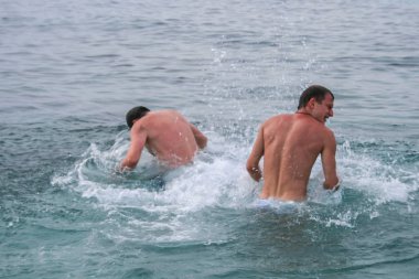 09.24.2008, Hersonissos, Girit, Yunanistan. Yunanistan Seyahat. bir grup genç insan dalgalar kıyıya yakın sıçramasına.