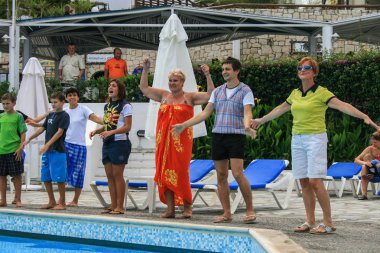 09.27.2008, Hersonissos, Girit, Yunanistan. Yunanistan Seyahat. Bir grup turist ve oynamaya ve yüzme havuzunun kenarında dans animatörler.
