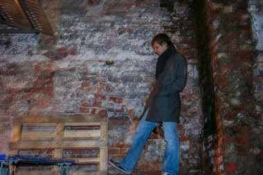 12.06.2008, Moskova, Rusya Federasyonu. Genç bir adam tarafından kırmızı tuğla duvar eski ayakta.