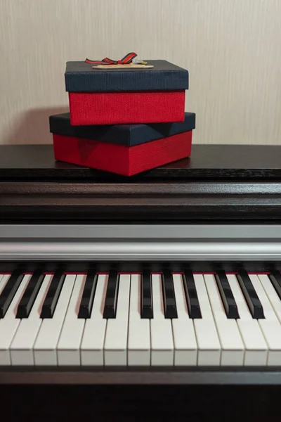 Two red gift boxes on the piano. Concept of congratulations and music.