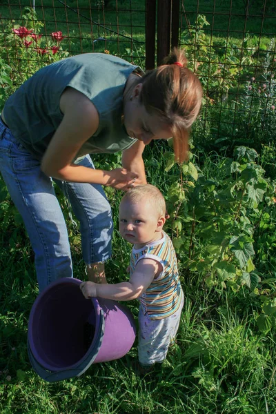 2009.07.18, Kaluga, Rusya Federasyonu. Anne ve oğlu yaz günde Bahçe. Küçük çocuk annesi bahçede yardım.
