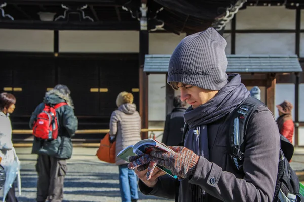 2013.01.04, Kyoto, Japonya. Avrupa turizm kaybolmak ve harita çalışması. Turist Japon tapınağın arka plan üzerinde.