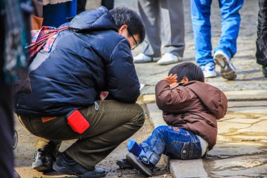 2013.01.05, Nara, Japonya. küçük çocuk yaramaz ve yere oturdu ve ayakkabılarını aldı.