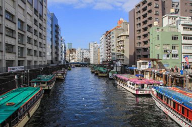2013.01.07, Tokyo, Japonya. Su üzerinde binalar ve tekneler arasında nehir. Tokyo bölgesinde ulaşım.