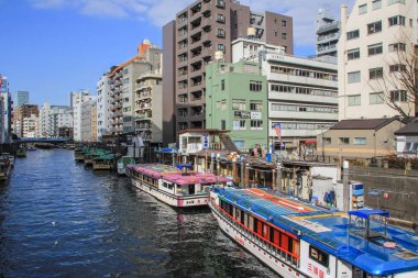 2013.01.07, Tokyo, Japonya. Su üzerinde binalar ve tekneler arasında nehir. Tokyo bölgesinde ulaşım.