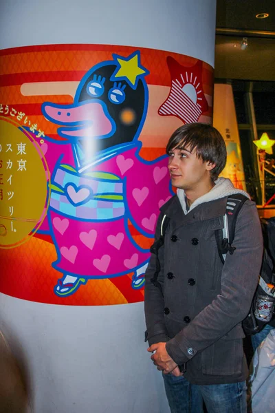 2013 站在日本搞笑图片墙边的欧洲年轻游客 — 图库照片