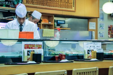 2013.01.08, Tokyo, Japonya. Sushi barda yemek Pişiriciler. Bir adam suşi ve rulo pişiriyor. Japonya Ulusal Gıda.