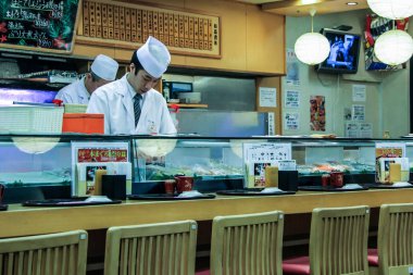 2013.01.08, Tokyo, Japonya. Sushi barda yemek Pişiriciler. Bir adam suşi ve rulo pişiriyor. Japonya Ulusal Gıda.