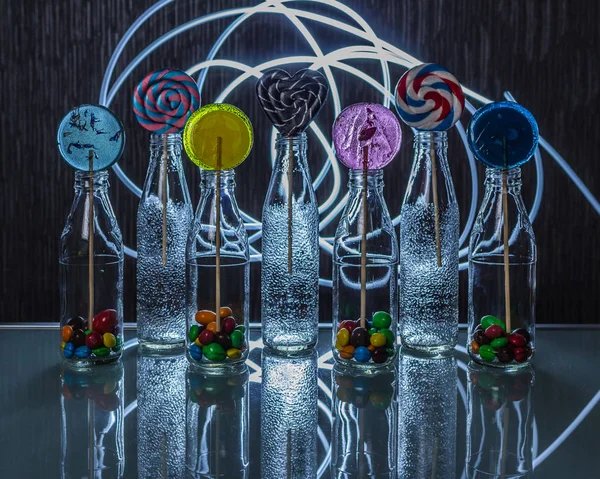 Heldere Kleurrijke Lollipop Snoepjes Flessen Staande Glazen Tafel Het Donker — Stockfoto