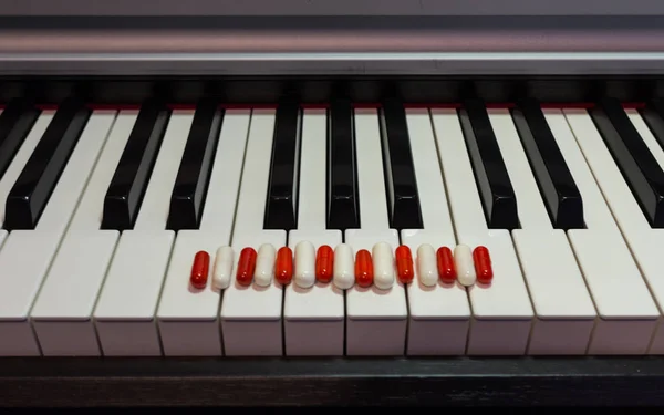 钢琴键盘上的药丸 音乐与健康的概念 — 图库照片