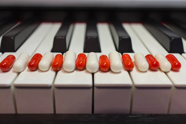 钢琴键盘上的药丸 音乐与健康的概念 — 图库照片