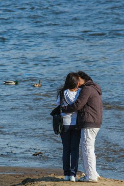 2010.03.27, Moskova, Rusya. Aşık genç çift nehir kıyısında ayakta ve suya bakıyor.