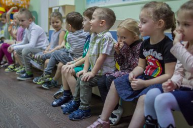 2019.01.22, Moskova, Rusya. Anaokulunda bankta oturan bir grup çocuk. Odada sevimli ve komik çocuklar.