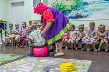 2019.01.22, Moskova, Rusya. Anaokulunda aktif oyunlar oynayan çocuklar. Komik erkek ve kız grubu topa atlama.