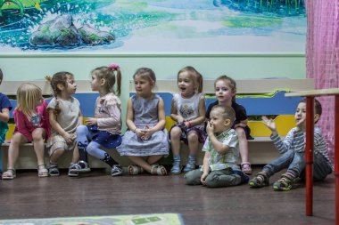 2019.01.22, Moskova, Rusya. Anaokulunda bankta oturan bir grup çocuk. Odada sevimli ve komik çocuklar.