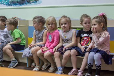 2019.01.22, Moskova, Rusya. Anaokulunda bankta oturan bir grup çocuk. Odada sevimli ve komik çocuklar.