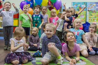2019.01.22, Moskova, Rusya. Mutlu yıllar partisinde Rus çocukların eğlence. Halıüzerinde oturan bir grup çocuk portresi.