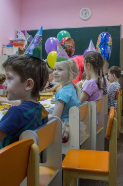 2019.01.22, Moskova, Rusya. Şenlik masasının yanında oturan çocuklar. Bahçede küçük bir çocuğun doğum günü kutlu olsun.